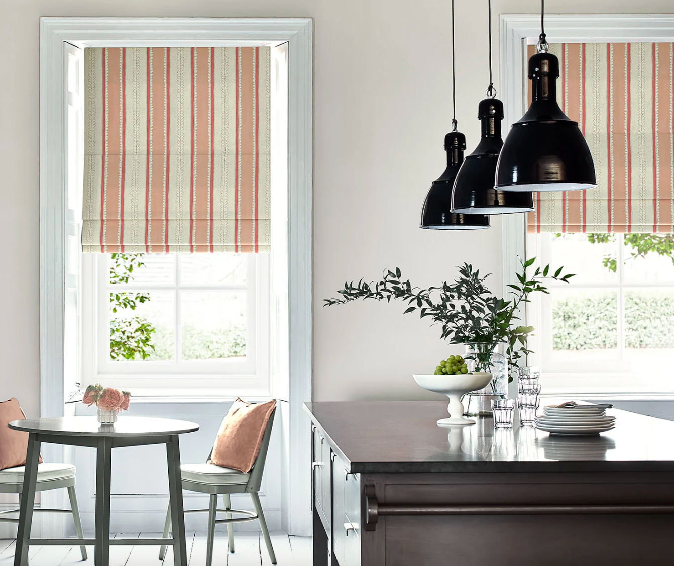 Modern kitchen with striped window blinds and pendant lights.